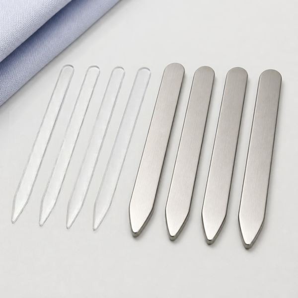 Plastic and stainless steel collar stays laid out together showing the difference in thickness.